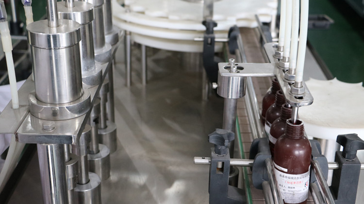 Máy chiết rót chai tròn 500ml có nắp bịt và bánh sao chạy